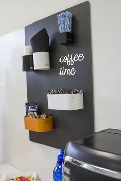 the coffee time sign is hanging on the wall next to some cups and other items