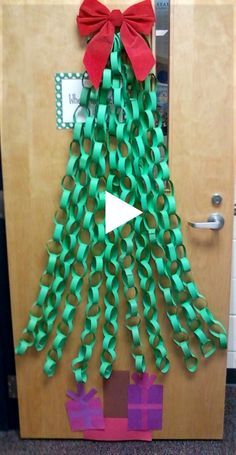 a door decorated to look like a christmas tree with green ribbons and bows on it