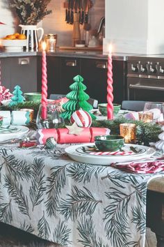 the table is set for christmas dinner with candles