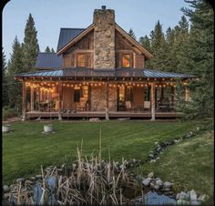 a log cabin is lit up at night with lights on the front and side windows