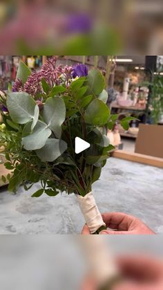 a person holding a bunch of flowers in their hand with the video showing them how to make a bouquet