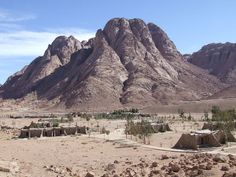 the desert is full of mountains and houses with no people on them in front of it