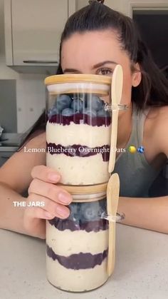 a woman is holding a jar with food in it