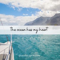 the ocean has my heart written on it with mountains in the backgroung