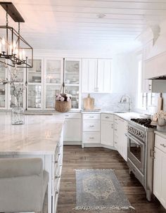 a large kitchen with white cabinets and wood flooring is seen in this image from the front view