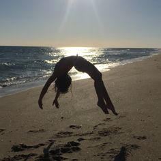 a person doing a handstand on the beach