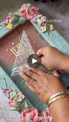 a woman is cutting out a card with scissors