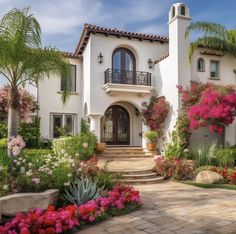 a house with many flowers and plants around it