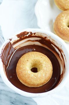 a chocolate covered doughnut in a white bowl