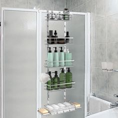 a bath room with a tub and a shelf filled with bottles on the shower wall