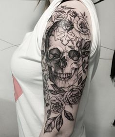 a woman with a skull and roses tattoo on her arm