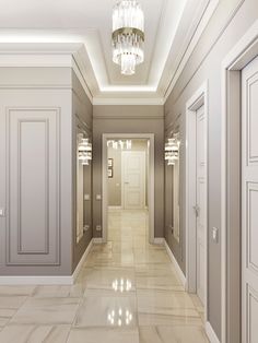 an empty hallway with chandelier and two doors leading to another room in the background