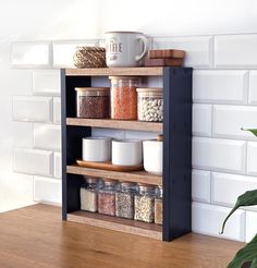 a shelf filled with lots of different types of spices on top of a wooden table