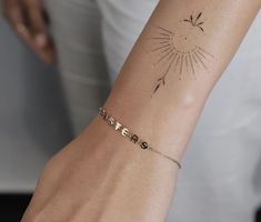 a woman's arm with a tattoo on it that reads sister and has a sunburst in the middle