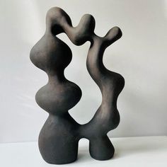 a black sculpture sitting on top of a white table