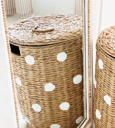 two wicker baskets sitting next to each other in front of a mirror with white polka dots on them