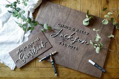 two wooden signs with writing on them sitting next to some pens and paper napkins