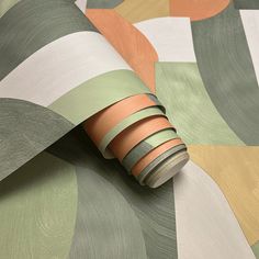 a roll of tape sitting on top of a green and orange wallpaper covered in circles