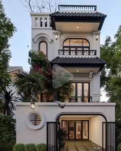 a large white house with lots of windows and balconies on the top floor