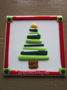 a christmas tree made out of crayons sitting on top of a white board