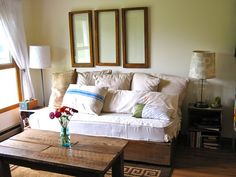 a living room with couches, tables and pictures on the wall in it's corner