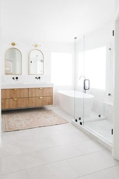 a large bathroom with two sinks and a bathtub next to a walk in shower