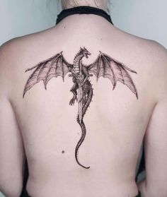 a woman with a dragon tattoo on her back