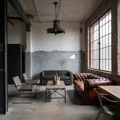 a living room with couches, chairs and tables in front of large open windows