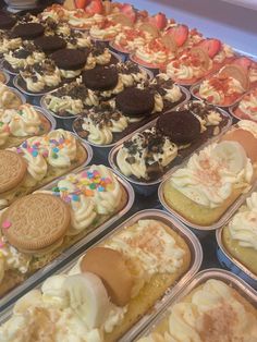 there are many cupcakes and cookies in the trays on this counter top