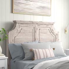 a bedroom with a bed, nightstand and painting on the wall above it's headboard