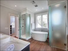 a large white bath tub sitting next to a walk in shower