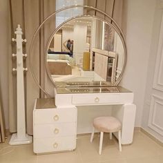 a white vanity with a mirror and stool