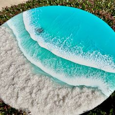 two pieces of blue and white sand on top of green grass with the ocean in the background