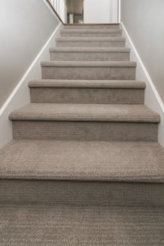 the carpeted stairs leading up to an open door