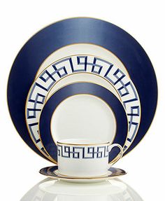 the blue and white dinnerware is set with an elegant design on it's side