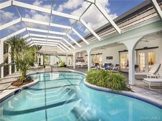 an indoor swimming pool surrounded by palm trees