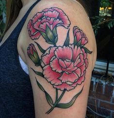 a woman's arm with pink flowers and green leaves on the left side of her shoulder