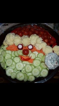 an image of a plate of food with vegetables in the shape of a clown face