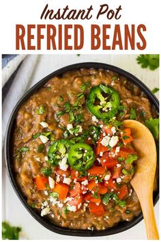 instant pot refried beans in a black bowl with a wooden spoon on the side