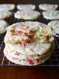 cookies with sprinkles are stacked on a cooling rack and ready to be eaten