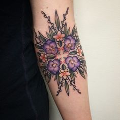 a woman's arm with flowers on it and the words tattoo written in black ink