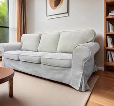 a living room with a couch, coffee table and bookshelf in it stock photo