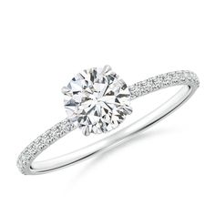 a diamond engagement ring with pave set diamonds on the band and an 18k white gold