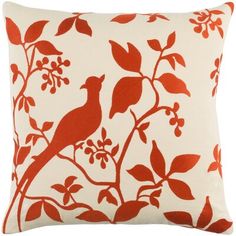 a red and white pillow with a bird on it's branch in the middle