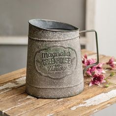 a metal mug sitting on top of a wooden table