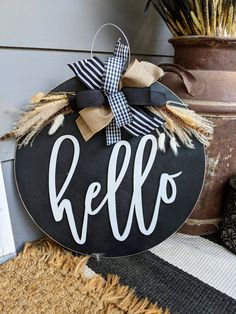 a black and white sign with the word hello hanging from it's front door