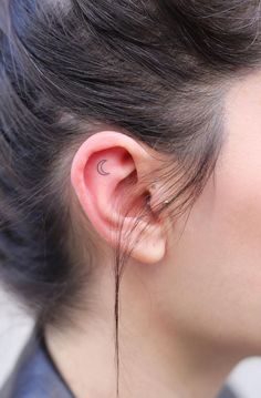 a woman's ear is shown with an arrow tattoo on it