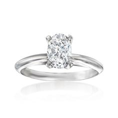 an oval cut diamond engagement ring on a white background