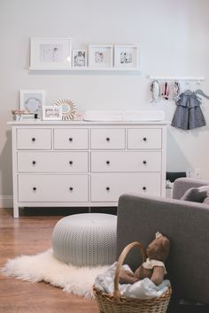 a baby's room with white furniture and pictures on the wall