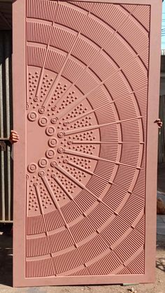 a pink door with an intricate design on the front and side, which is made out of